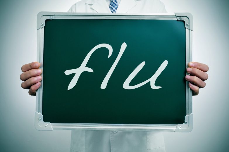 Person with a sign that says "Flu"