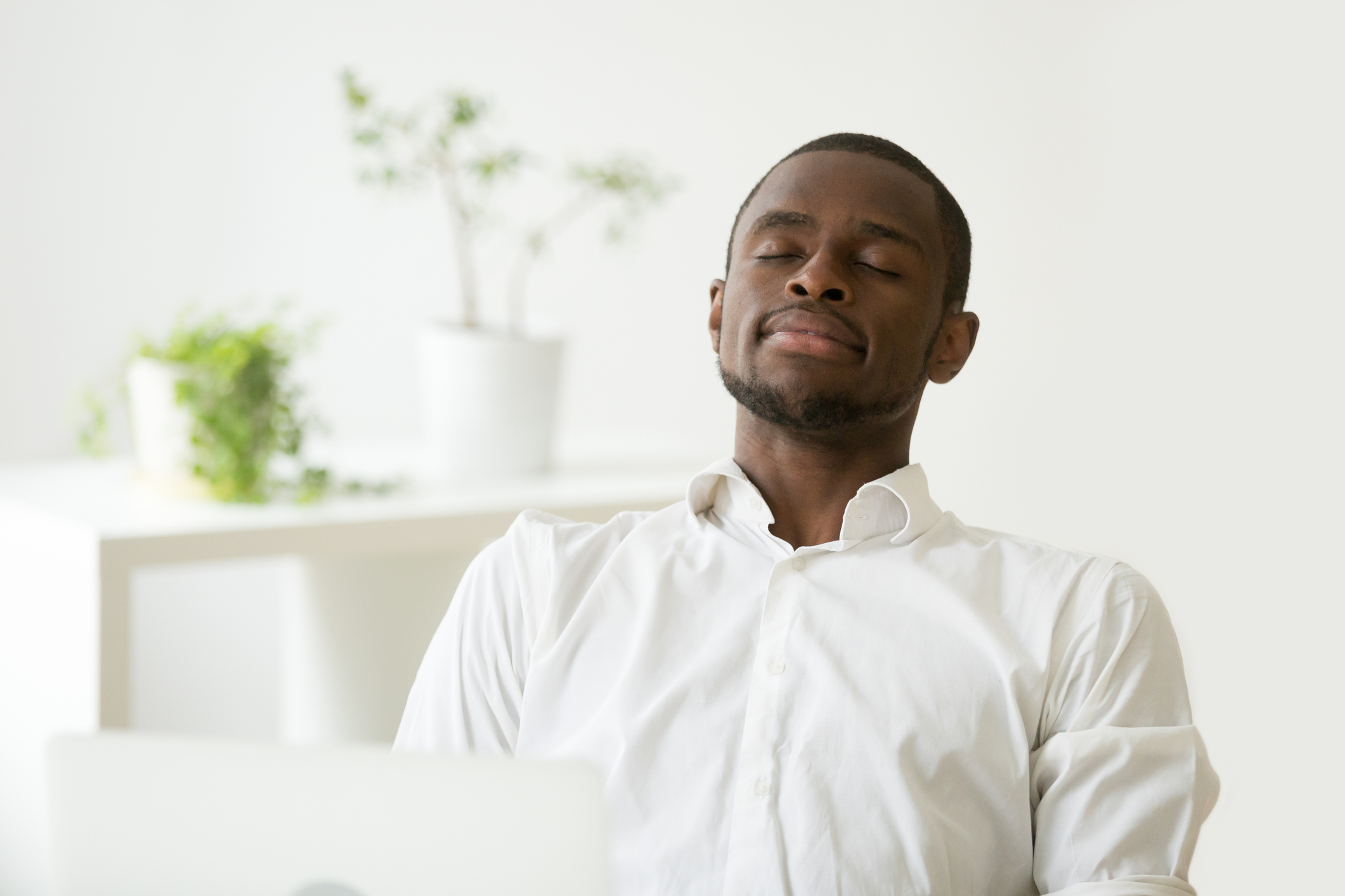 Man closing eyes at work