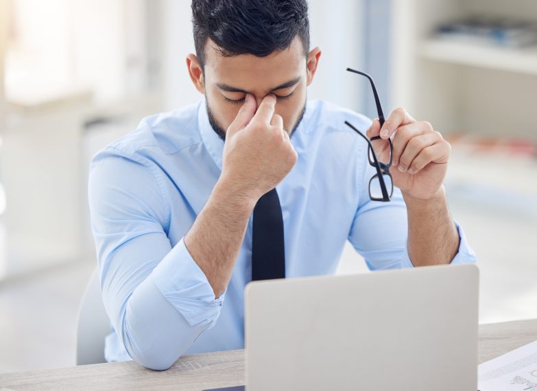 Man looking down at computer in frustration