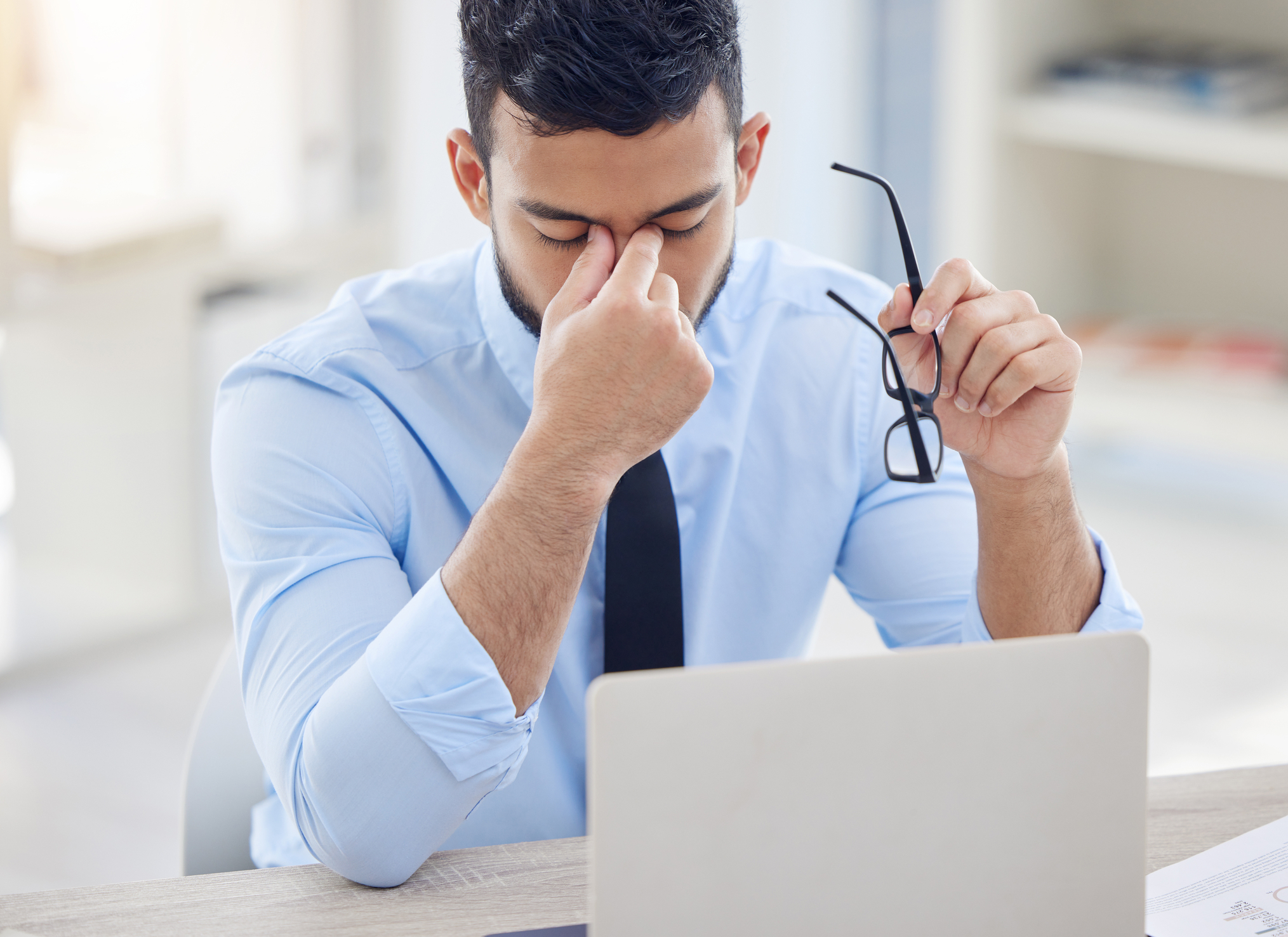 Man looking down at computer in frustration