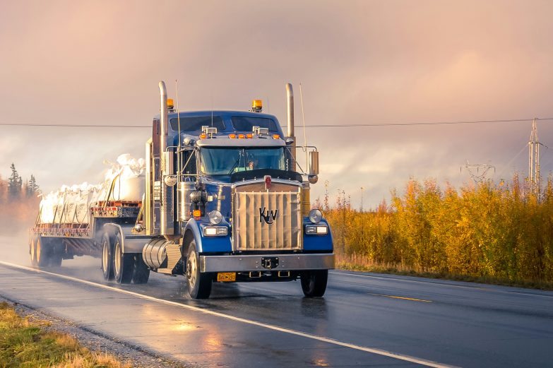 A truck driving along a wet road.