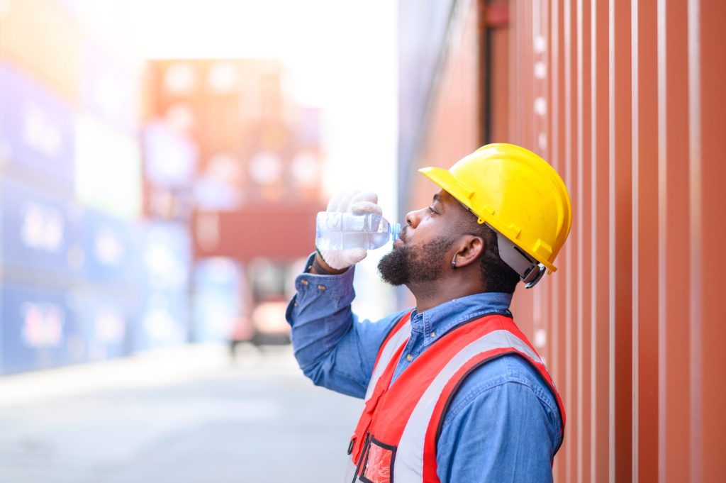 Outdoor worker drinking water to prevent heat illness.